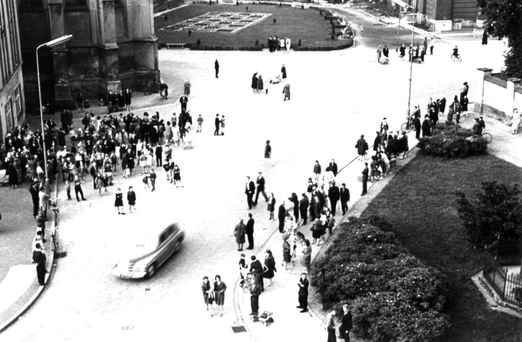 Plac Zamkowy w Brzegu. Ludzie zbierają się pod budynkiem 